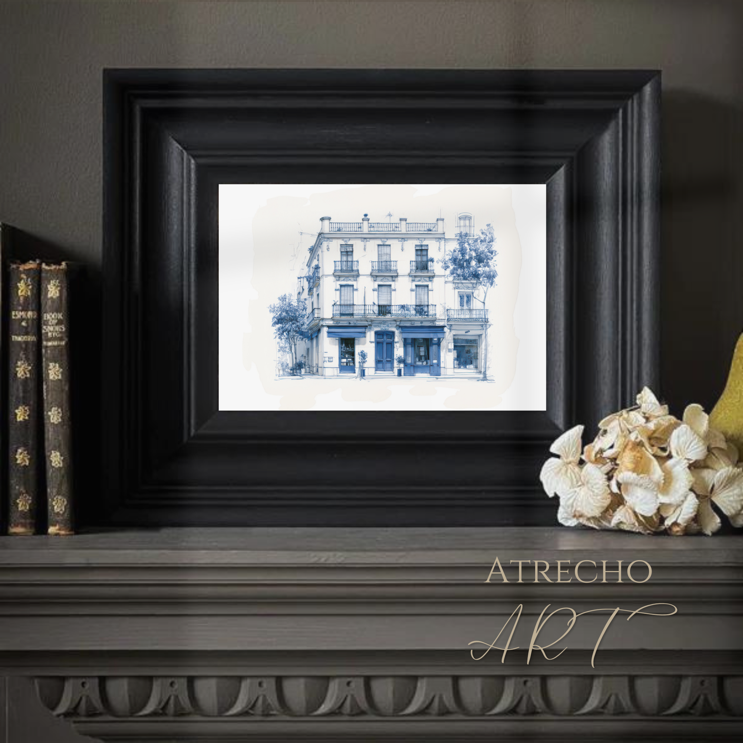 Mediterranean townhouse sketch on a neutral wall above a console with books and a vase, calm styled room by Atrecho Art